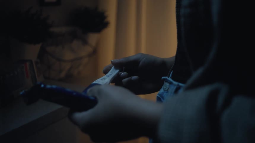 Woman removes a pregnancy test from its wrapper then fidgets in place