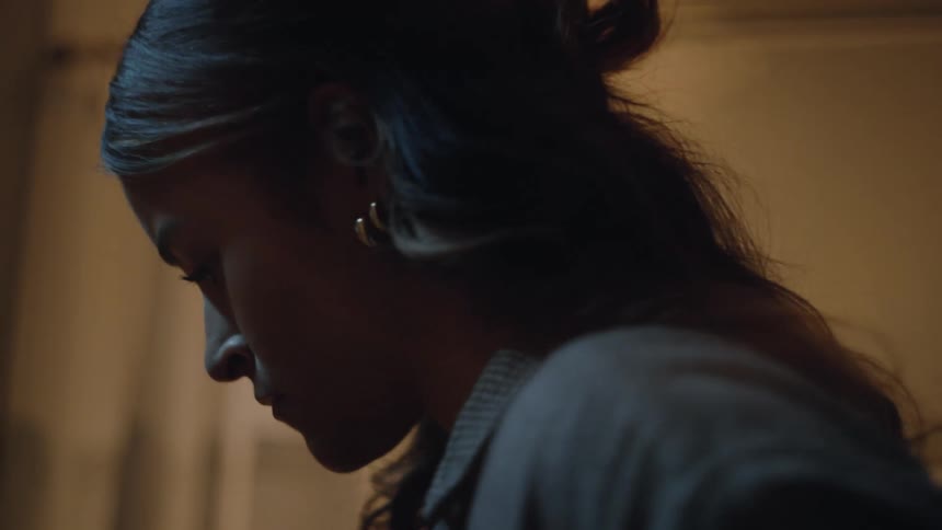 Woman silently looks at a pregnancy test with an apprehensive expression