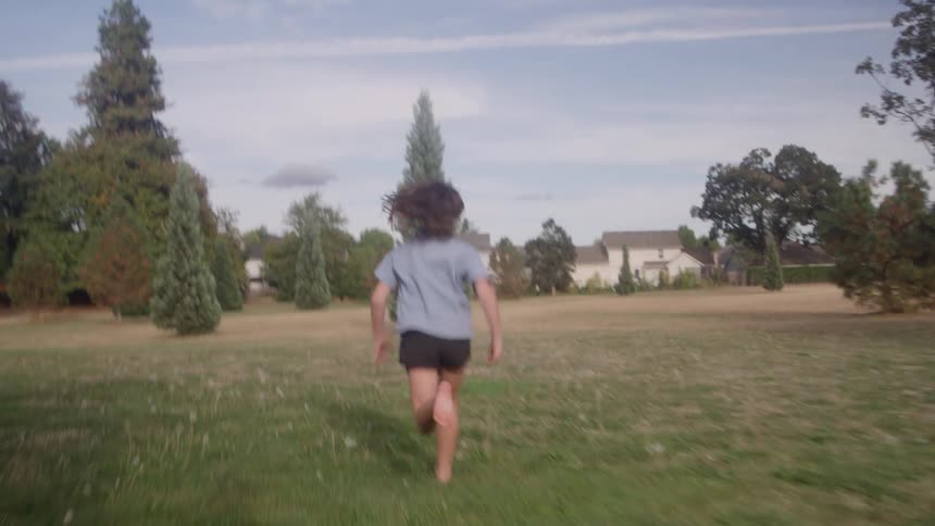 The child is running on the green field