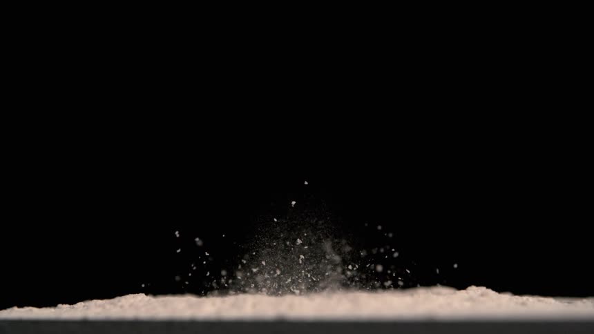 Close up of a white powder spread on a vibrating surface