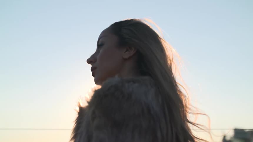 A woman walking as the sun sets
