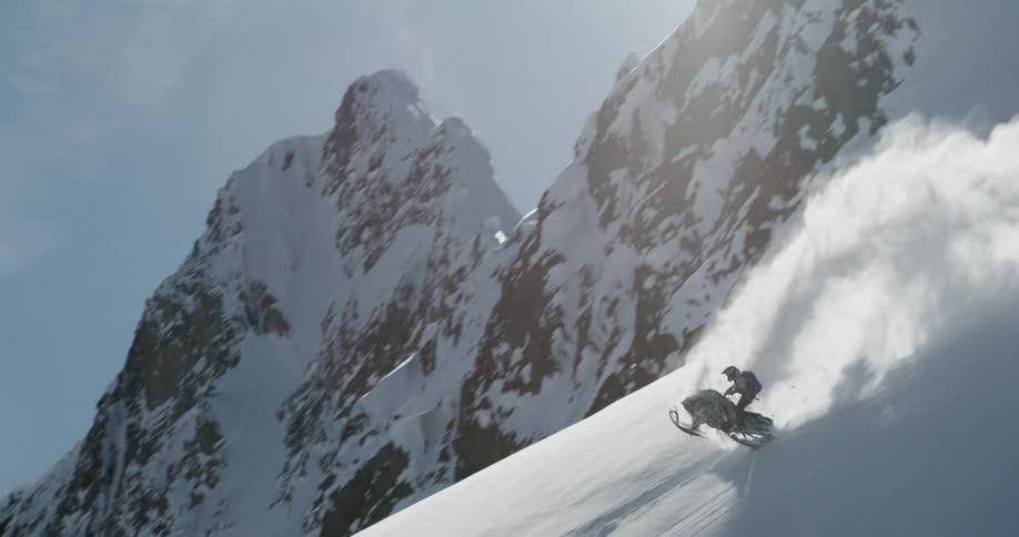 Snowmobile jumping on a steep snowcovered slope