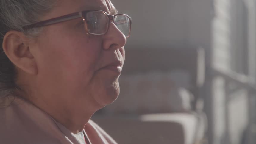Elderly woman drinks a hot beverage on a sunny morning