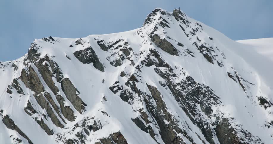 Snowcovered rocky peak under a clear blue sky
