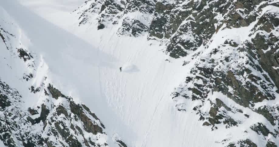Skier descending a steep slope between snowcovered rocks