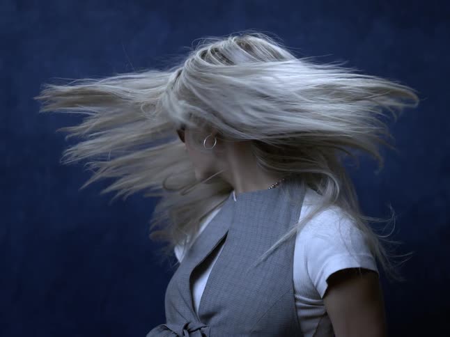 The woman whips her hair back and forth