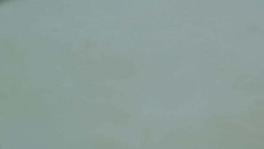 Hot mud bubbles on turbulent surface beneath soft mist
