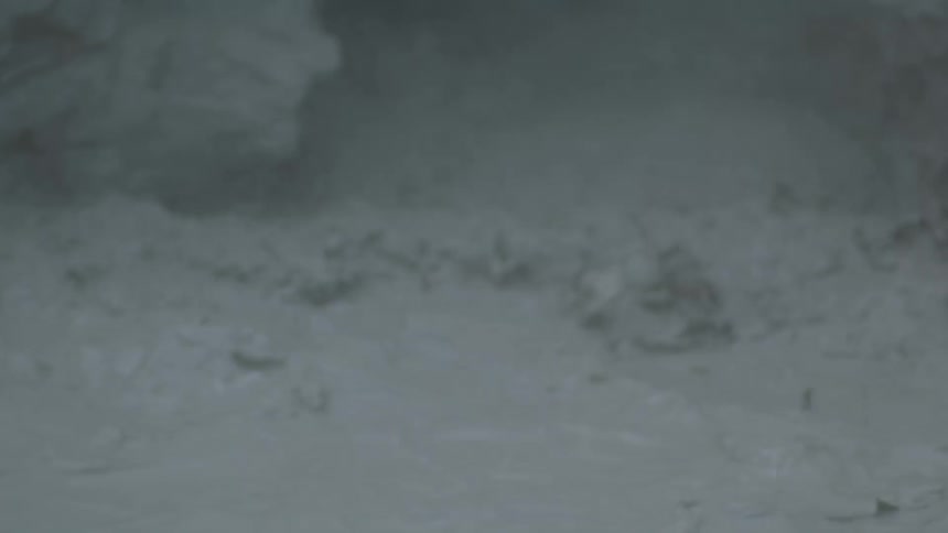 A close view of murky grey water churns and ripples as suspended silt gives the surface a smoky look