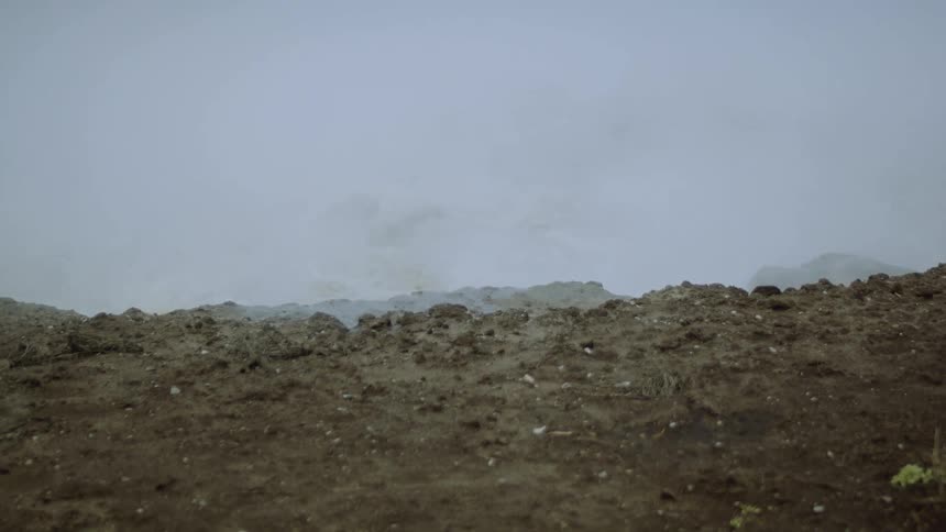 Steam and fog rise form the bubbling hot spring