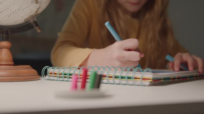 The child is writing in her notebook