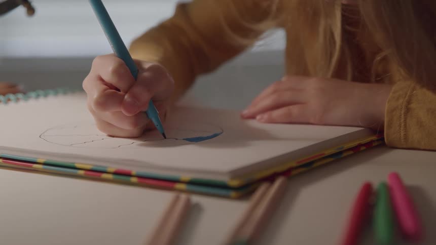 A person draws in a notebook