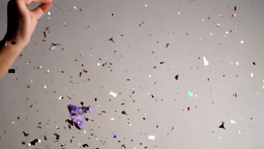 The balloon full of glitter is popped with a needle