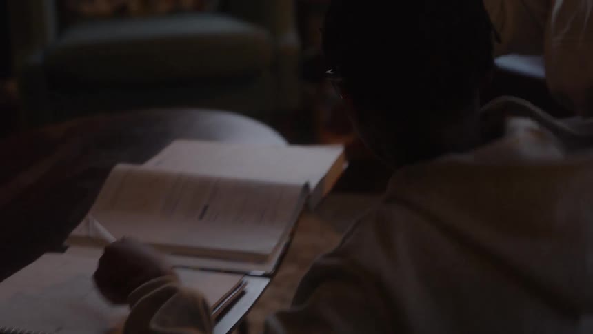 Mother and son hug warmly in a cozy dimly lit living room