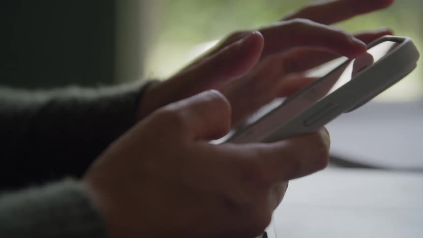 Closeup of hands scrolling and interacting with a smartphone screen
