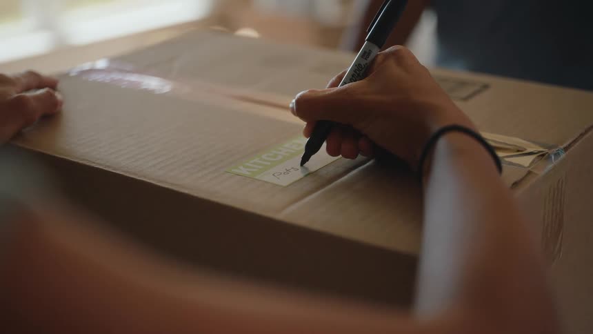 A person writes on a box