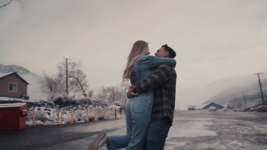 A man picks up partner and spins her around in the neighborhood street