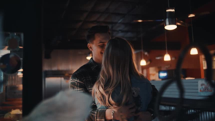 A young couple plays a crane game inside of a restaurant and wins