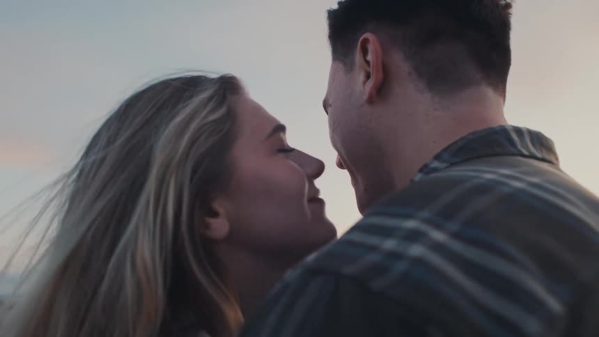 The woman kisses the man on the cheek