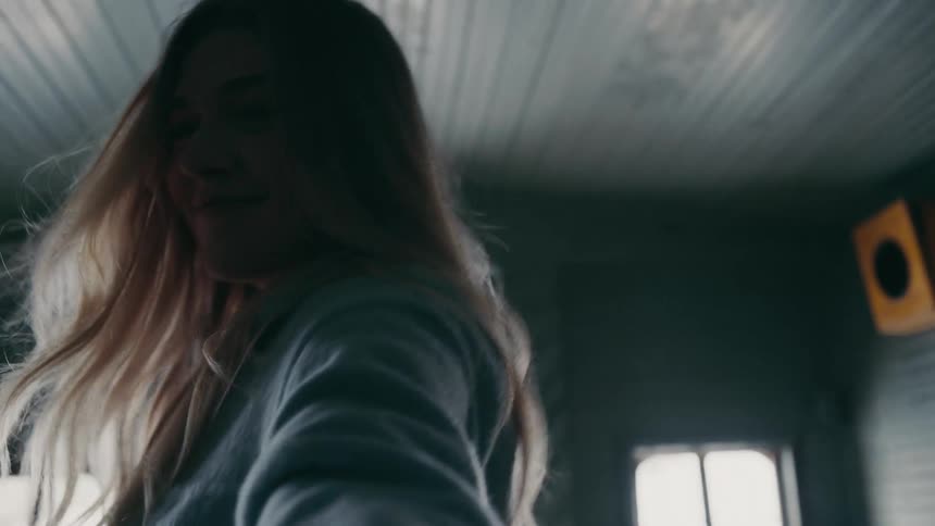 A woman runs down a narrow aisle reaching her arm as if shes leading someone