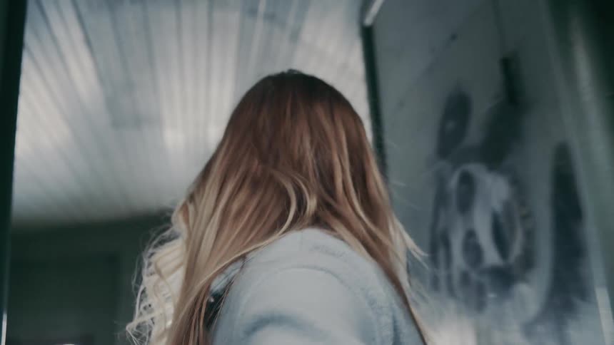 The woman smiles while walking through the hallway