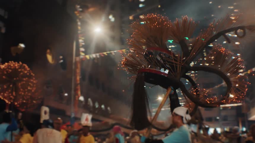 Dragon lit by sparks is lifted during a night celebration