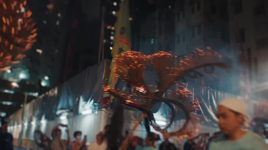 Fire dragon parades through the streets amid the crowd and sparks