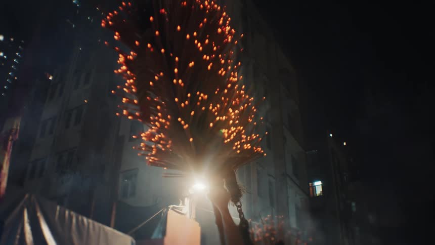 Participants carry a flaming dragon structure during a nighttime celebration