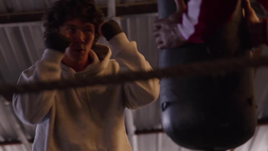 Boxer delivers powerful punches to the punching bag with focus and intensity