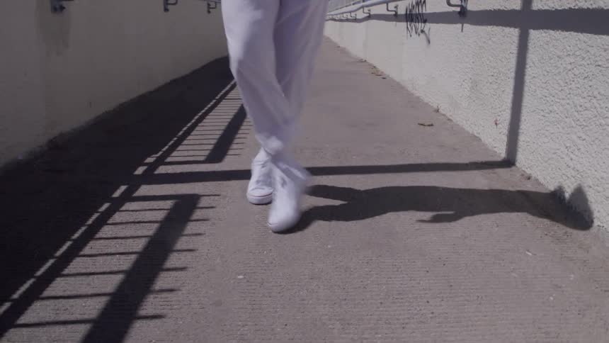 Dance steps in motion on the sunlit sidewalk
