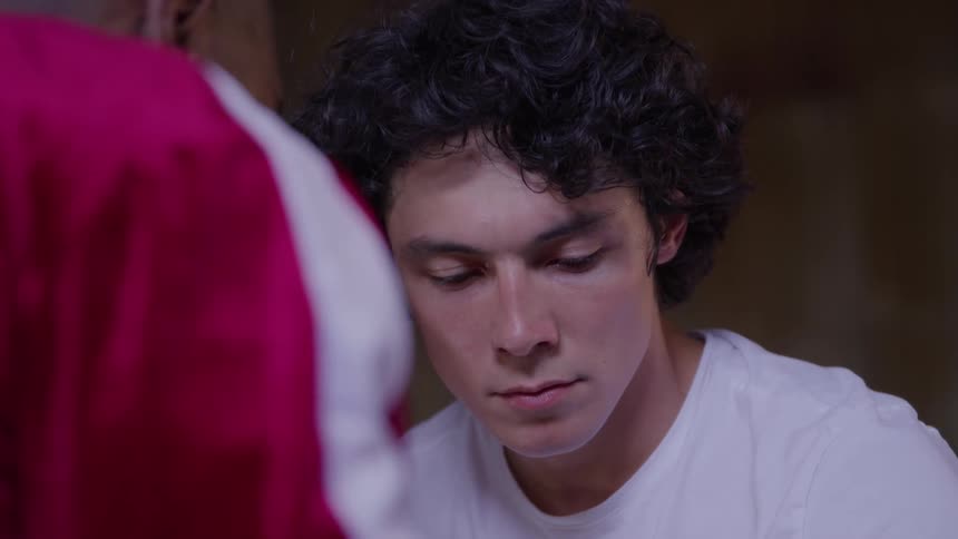 Close up of a male trainer conversing with a young male boxer indoors