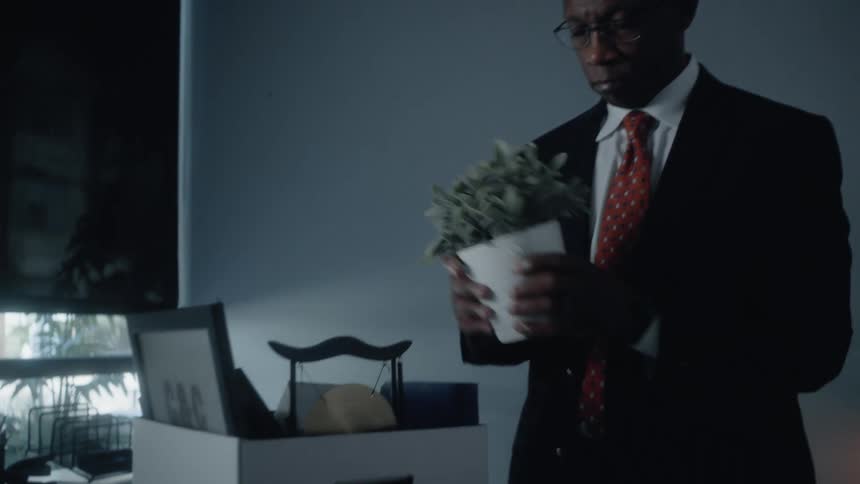Man packs personal belongings at his desk in the office after resigning