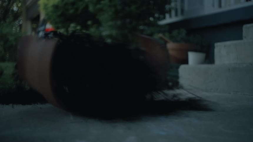 A clay pot is broken with dirt spilled near the porch steps