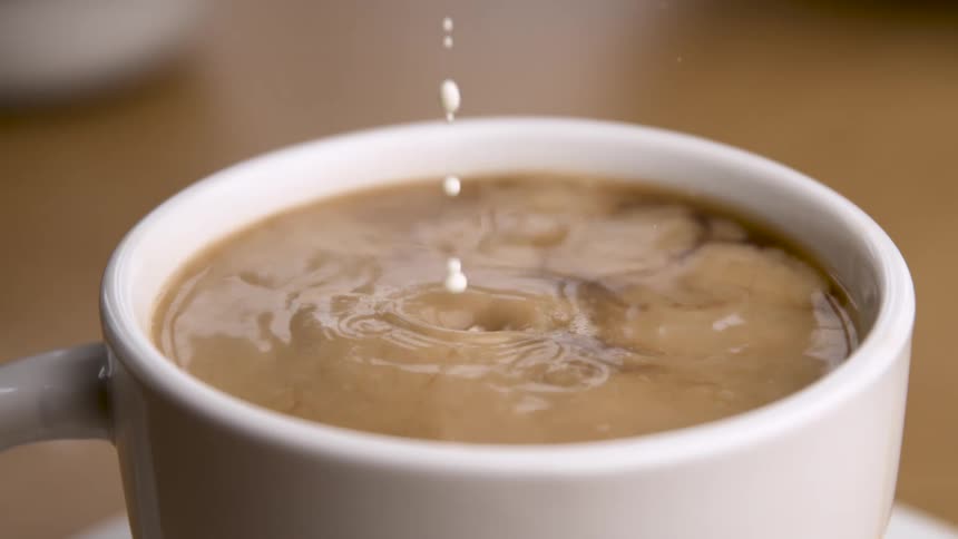 The milk mixes with the coffee as it is poured