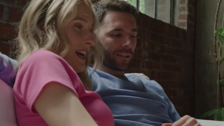 The man and woman talk together on the couch