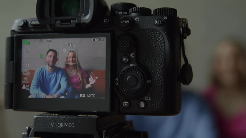 The man and woman can be seen through the cameras viewfinder