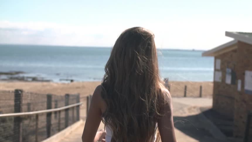 Woman walking towards the beach
