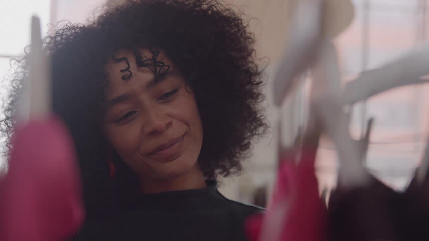 A black smiles as she shops through clothing in a boutique