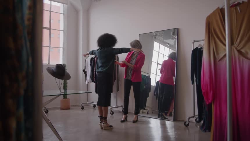 A saleswoman measures a customer in a modern well lit boutique