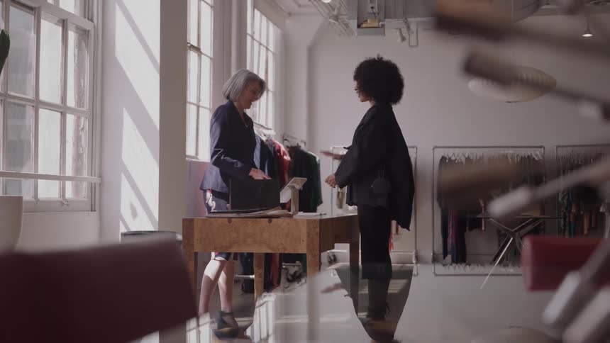 A sales woman cashes out a customer at a clothing store