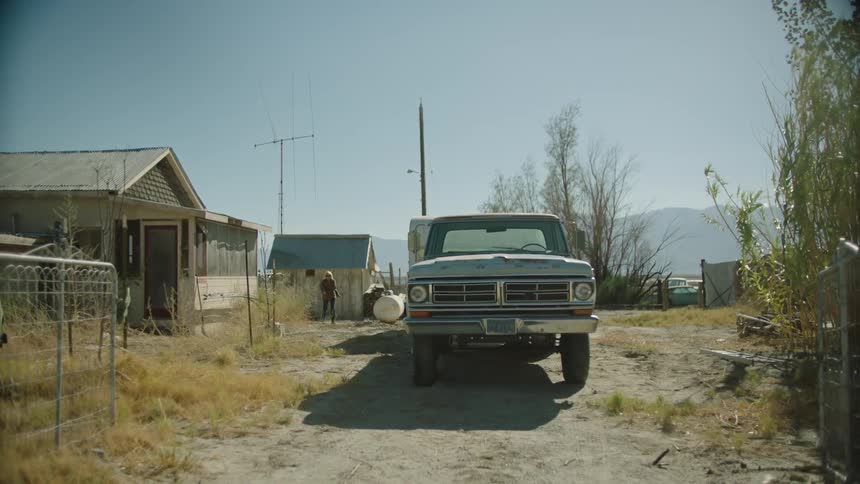 A person walks by a house towards a truck