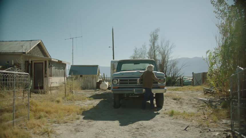 A woman walks past a blue truck