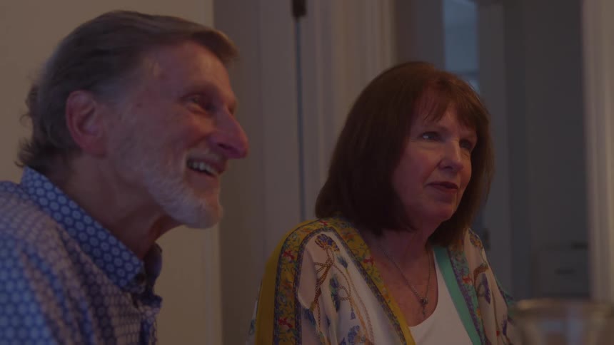 Man and woman sitting side by side smiling during a conversation