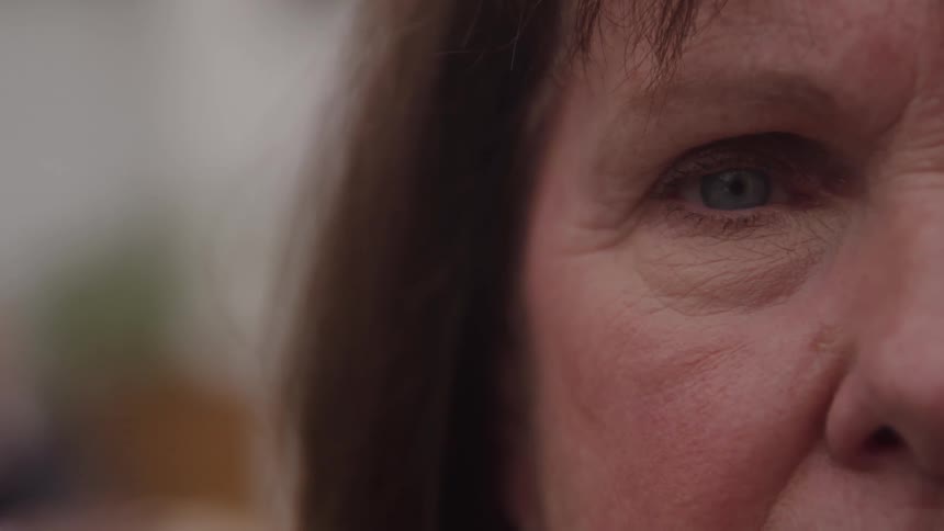 Closeup of an older womans face focusing on her blue eye