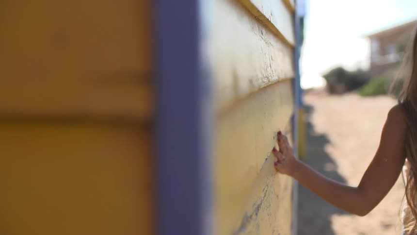 Girl tracing her hand across a yellow wall