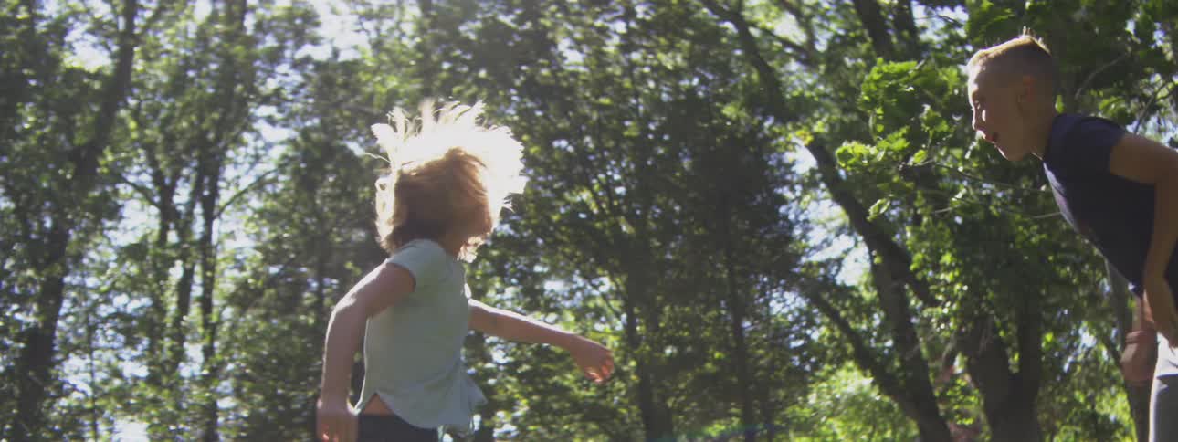 Children jump around playing in the park