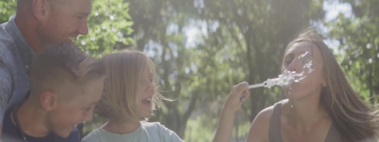 Family enjoying time outdoors as the child prepares soap bubbles