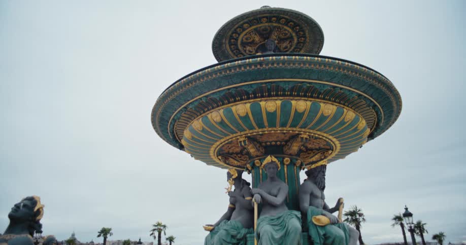 The fontaine des mers in place de la concorde paris features gold and blue sculptures with water flowing at midday