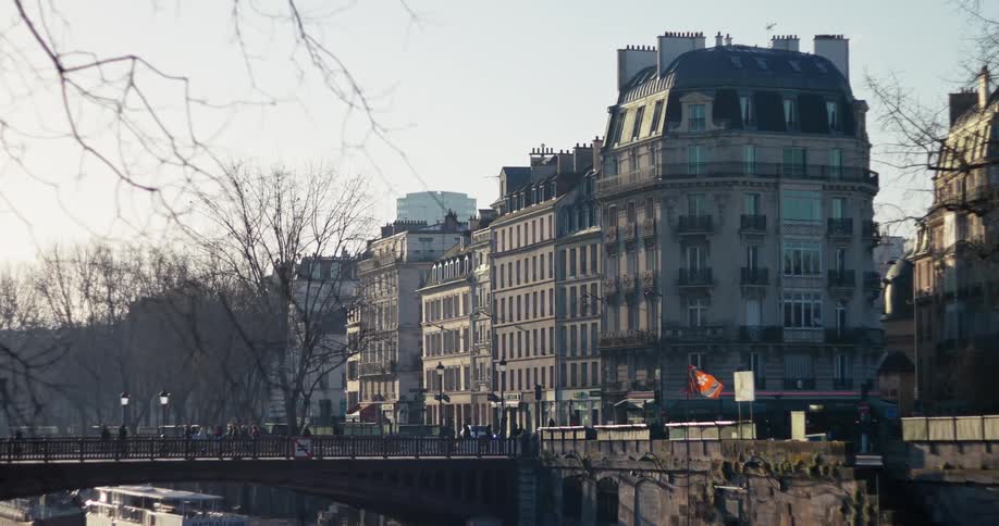 Pedestrians walk over a bridge and the intersecting street in a residential area on a winter day