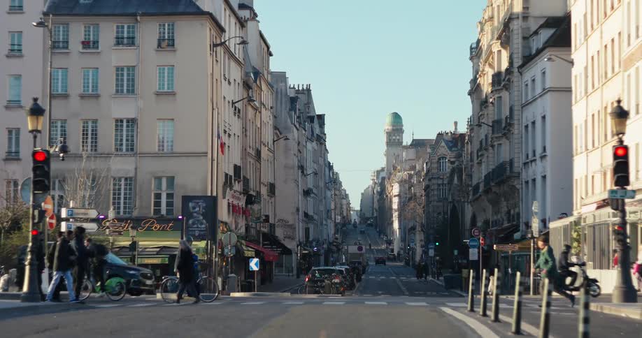 Busy street lined with old buildings under a clear sky