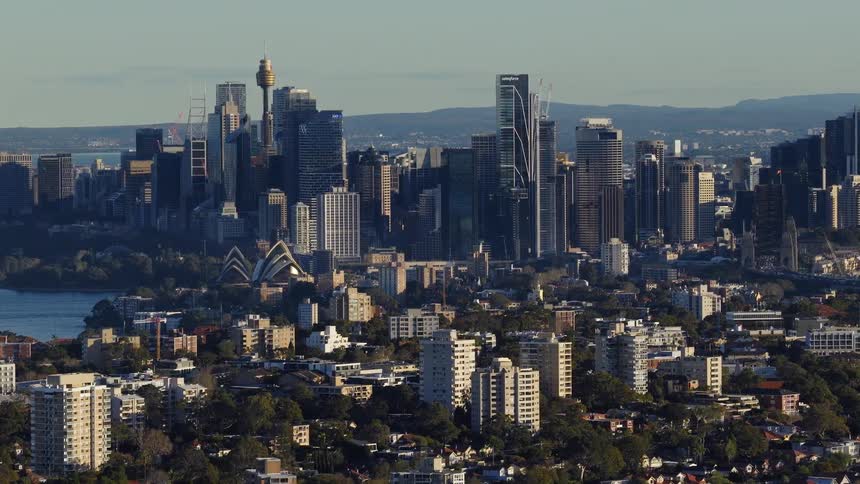 The video is a highangle shot providing a panoramic view of the sydney skyline in australia the dense cluster of modern skyscrapers and highrises is clearly visible with the distinct silhouette of the sydney opera house in the middle groun